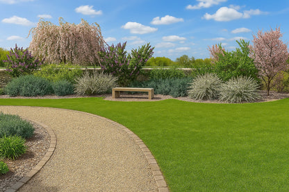 The flowering corner in spring - a picturesque bed with blossoming trees and shrubs by a wall, creating a perfect spot for rest and quiet contemplation of nature